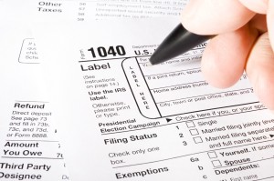 Stock image of man filling out 1040 Tax form